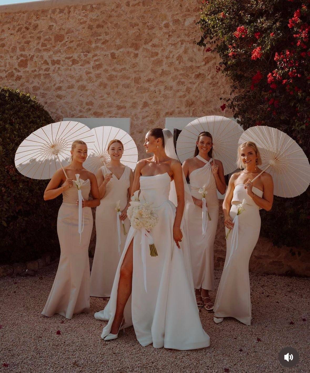 Mariée et ses demoiselles d'honneur avec des ombrelles blanches 